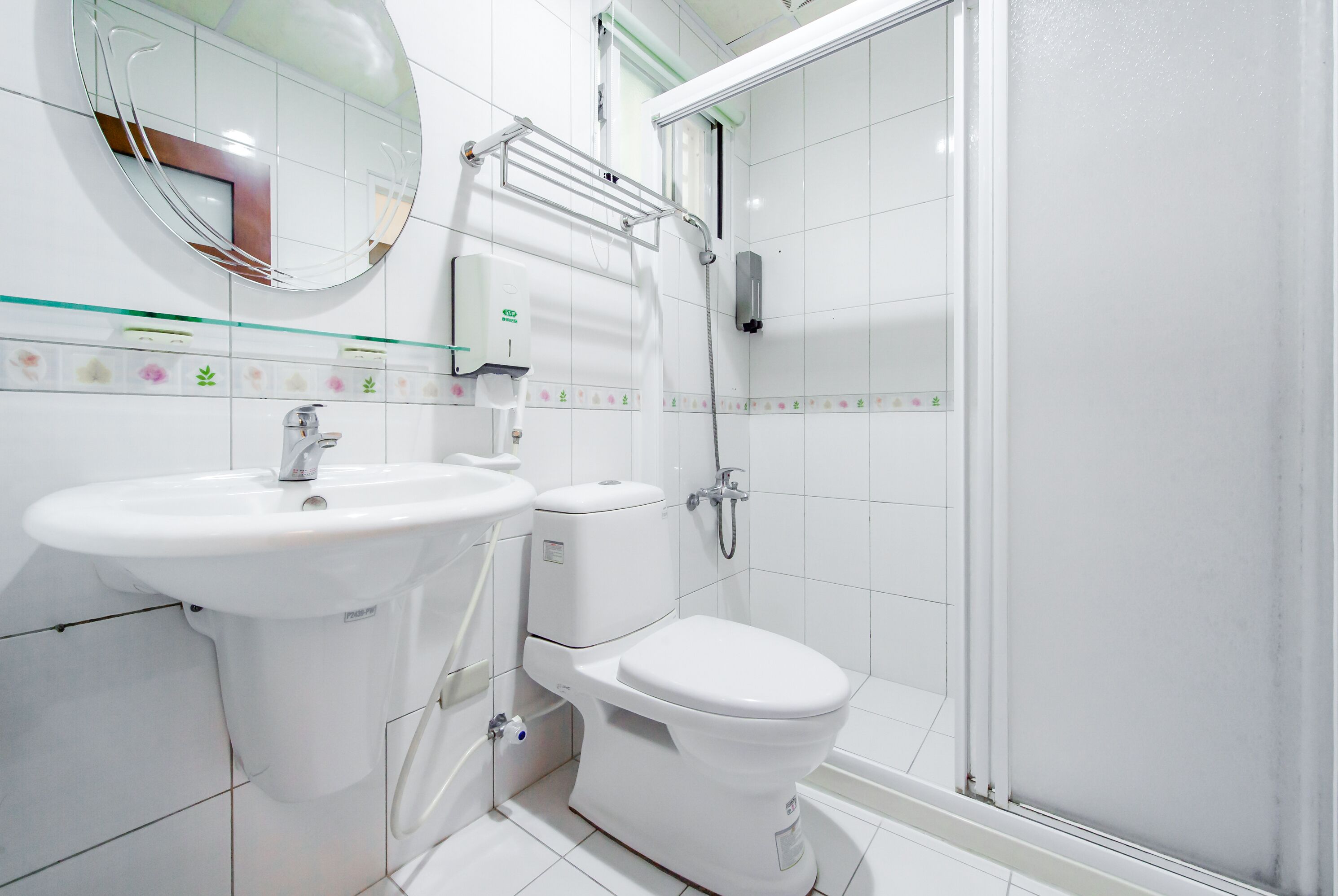 Une salle de bain moderne équipée de toilettes, d’un lavabo et d’une douche à parois de verre.
