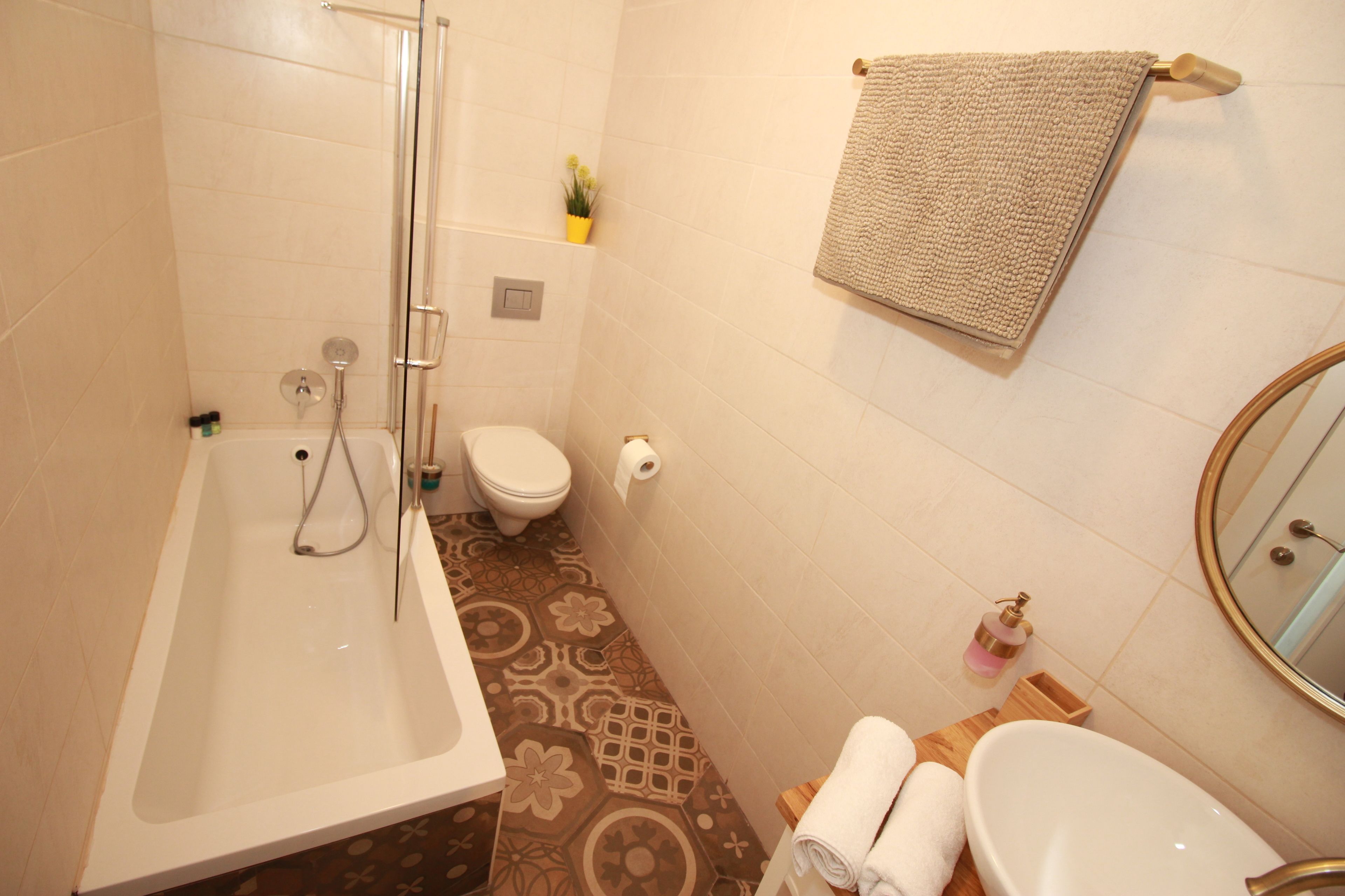 Ein Badezimmer mit Badewanne, Toilette, Waschbecken und Spiegel.