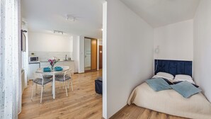 A modern apartment with a kitchen, dining area, and a bedroom.