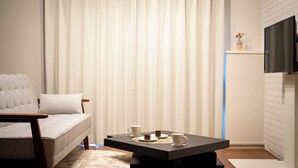Un salon moderne avec un canapé, une table basse et un téléviseur fixé au mur.