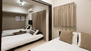Une chambre d’hôtel avec deux lits, une petite table et une fenêtre avec des rideaux.