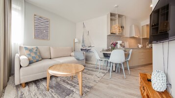 Uma sala de estar moderna com sofá, mesa de centro e área de refeições.