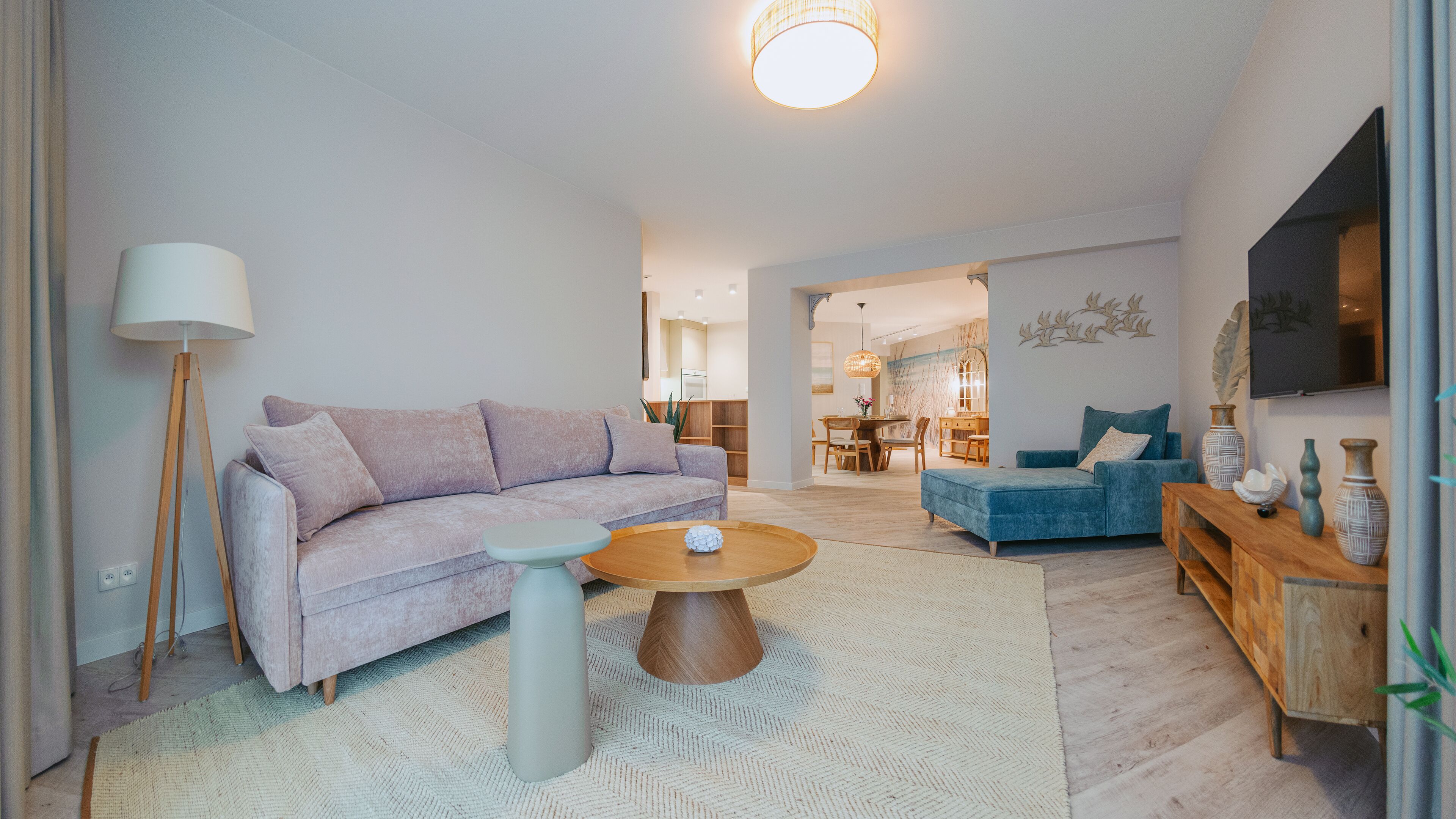 Un salon moderne avec un canapé, une table basse et un téléviseur.