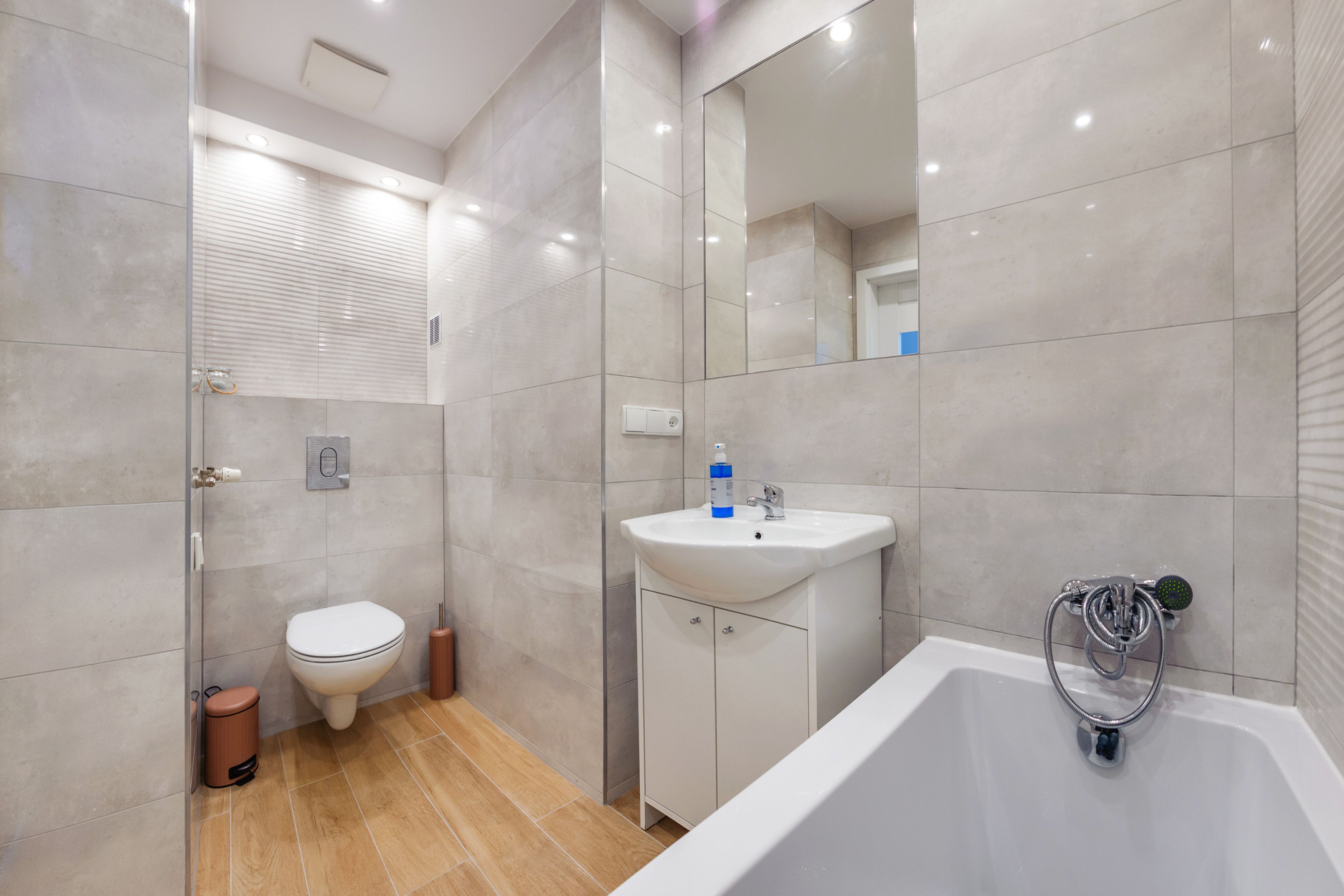 A modern bathroom with a toilet, sink, and bathtub.