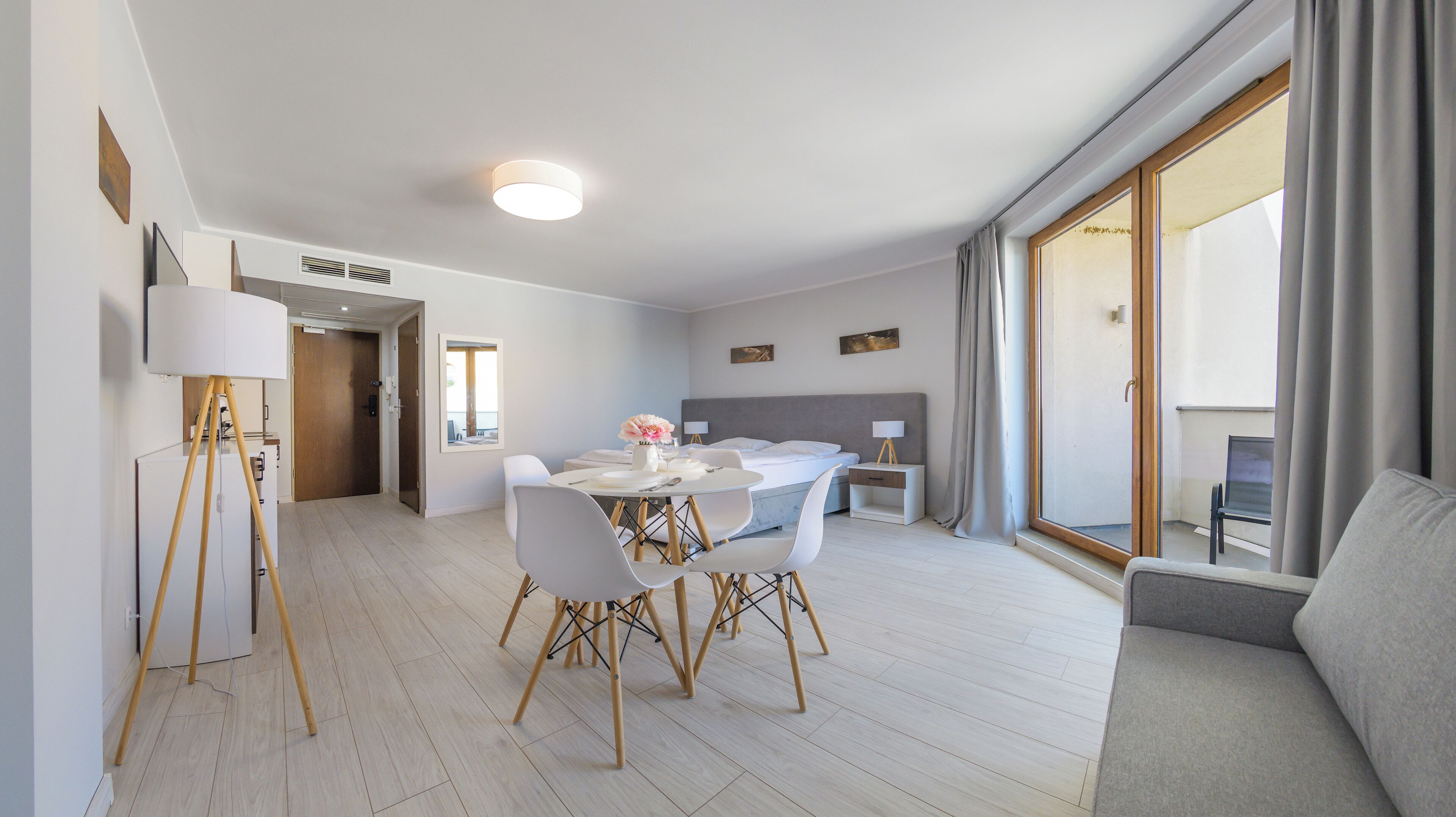 Une chambre d’hôtel moderne comprenant un coin repas, un lit et un balcon.