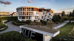 A modern multi-story residential building with balconies, a driveway, and a well-maintained garden. - Apartamenty Sun&Snow Na Klifie (Wladyslawowo)