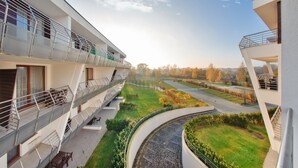 A modern building with multiple balconies, a curved pathway, and a landscaped garden. - Apartamenty Sun&Snow Na Klifie (Wladyslawowo)
