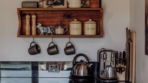 Una cocina con armarios de madera, una estufa y varios utensilios.