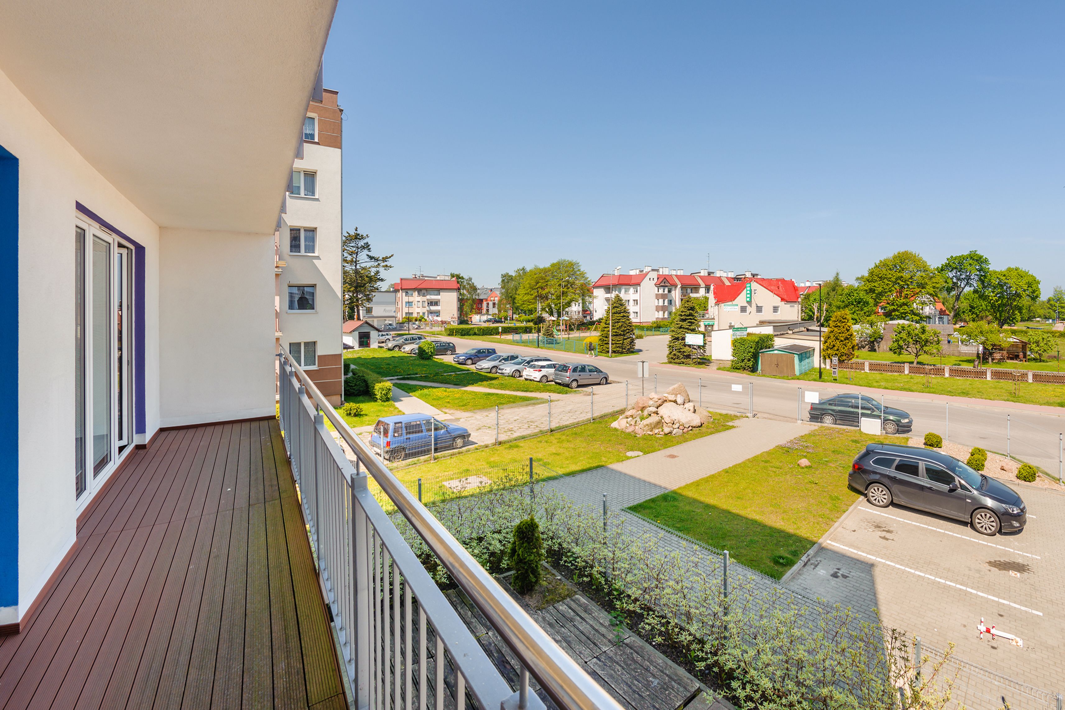 Un balcone con vista su un parcheggio e degli edifici.