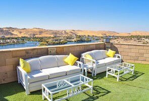 Una piscina al aire libre, sombrillas, sillones reclinables de piscina