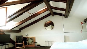 A room with a sloped ceiling, a bed, a mirror, a desk, and a chair. - Venezianamente - Ca'Zane (Venice)