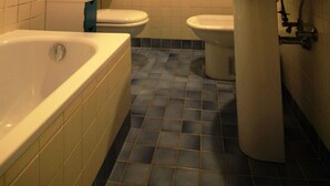A bathroom with a bathtub, toilet, and sink, featuring blue tiles and white fixtures. - Venezianamente - Casa del Batelo (Venice)