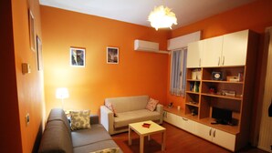 A living room with a sofa, a coffee table, and a TV stand. - Venezianamente - Casa del Batelo (Venice)