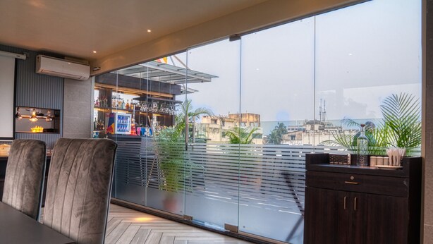 Een modern interieur met een eethoek, een bar en grote ramen met uitzicht op de stad.