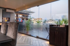 A modern interior with a dining area, a bar, and large windows offering a city view. - The Samilton (Kolkata)