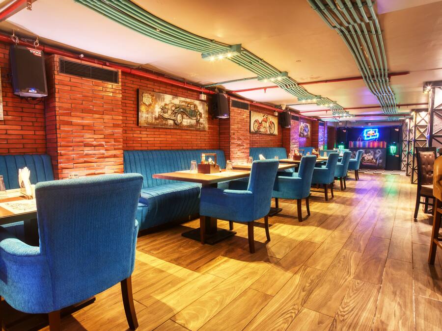 Un restaurante con paredes de ladrillo, cabinas azules y suelo de madera.