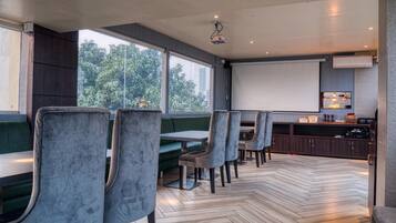 Un restaurante moderno con asientos tipo banca tapizados en gris y suelo de madera con diseño de espiga.