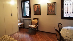 A room with wooden beams, a bed, two chairs, a radiator, and a window with a view. - Venezianamente - Residenza Formosa (Venice)