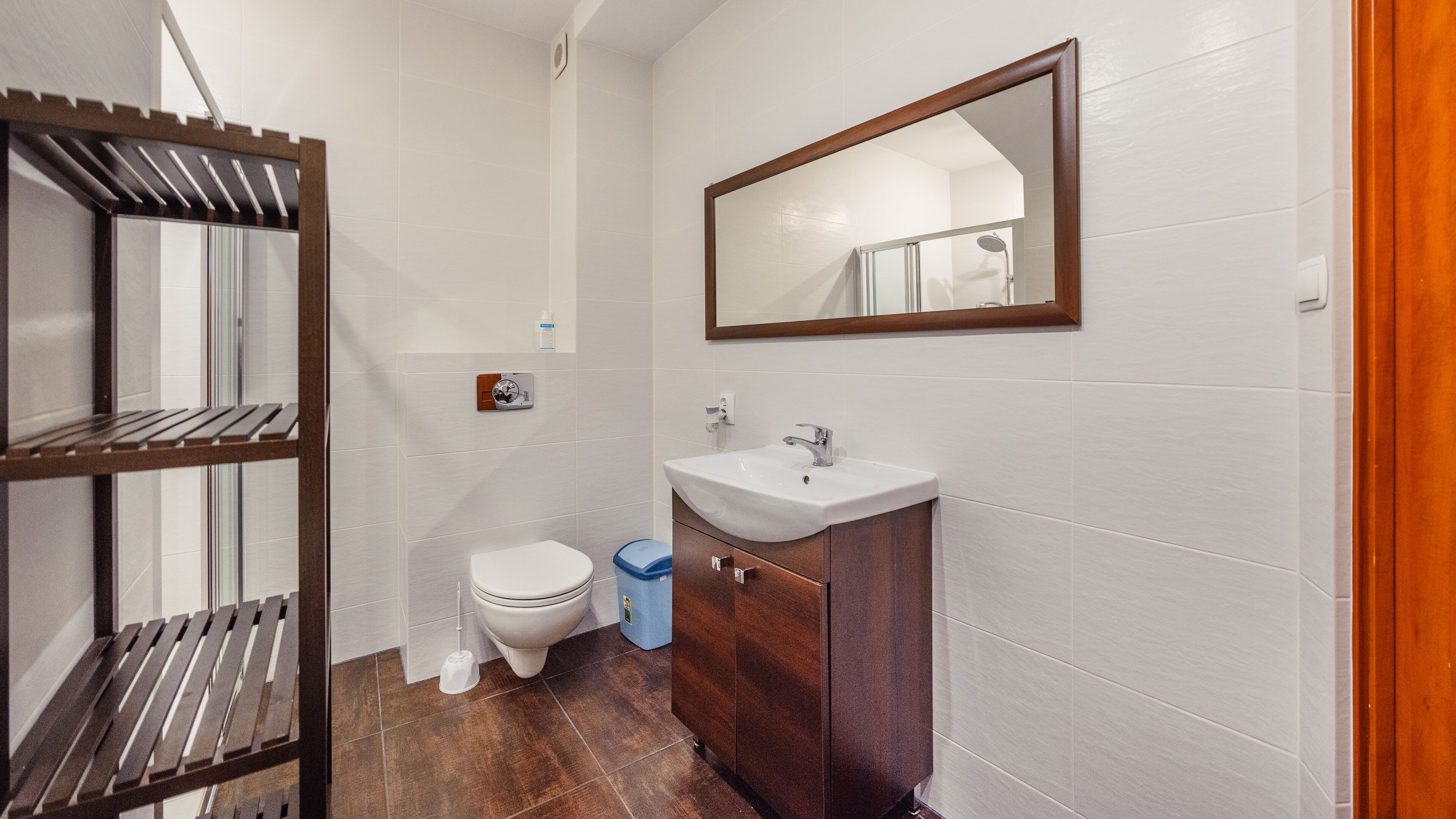 A bathroom with a toilet, sink, and mirror.