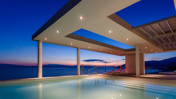 A modern indoor pool with a clear view of the ocean and mountains at dusk. - 600m² homm Luxury Villa Sea Side Evia 16ppl (Istiaia-Aidipsos)