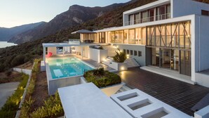 A modern two-story house with a swimming pool, outdoor seating, and a view of the mountains. - 600m² homm Luxury Villa Sea Side Evia 16ppl (Istiaia-Aidipsos)