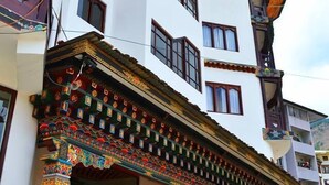 Un immeuble à plusieurs étages, de style architectural traditionnel, caractérisé par une façade en bois et des éléments décoratifs colorés.