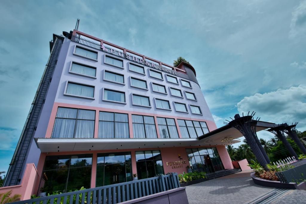 A multi-story hotel with a modern facade, large windows, and a covered entrance area.