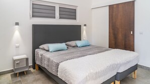 Una camera da letto moderna con un letto, comodini, un armadio e una finestra con tende.