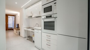 A modern kitchen with white cabinetry, a built-in microwave, oven, and dishwasher.