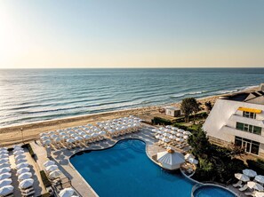 A resort with a swimming pool, beach umbrellas, and a view of the ocean. - AluaSun Helios Beach – All Inclusive (Obzor)