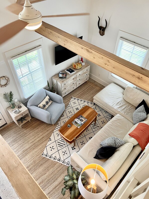A modern living room with a sofa, coffee table, and a TV mounted on the wall. - Charleston Guest House- Easy parking! Quiet, safe neighborhood! Close to Dwntn! (Charleston)