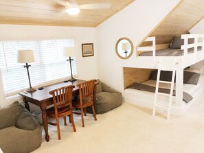 A cozy room with a wooden desk, two chairs, a bunk bed, and a ceiling fan. - Charleston Guest House- Easy parking! Quiet, safe neighborhood! Close to Dwntn! (Charleston)