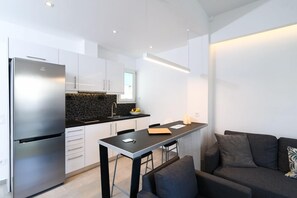 Apartamento, 1 quarto | Cozinha americana privada | Geladeira grande, cooktop, talheres/pratos/utensílios de cozinha