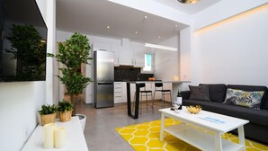 A modern living space with a kitchen, a dining area, and a seating area with a sofa and coffee table. - 45m2 homm Renovated Flat in Neos Kosmos Roumpesi str (Athens)