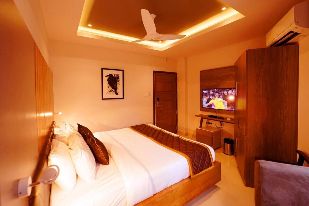 Una habitación de hotel moderna con una cama, un televisor y un escritorio.