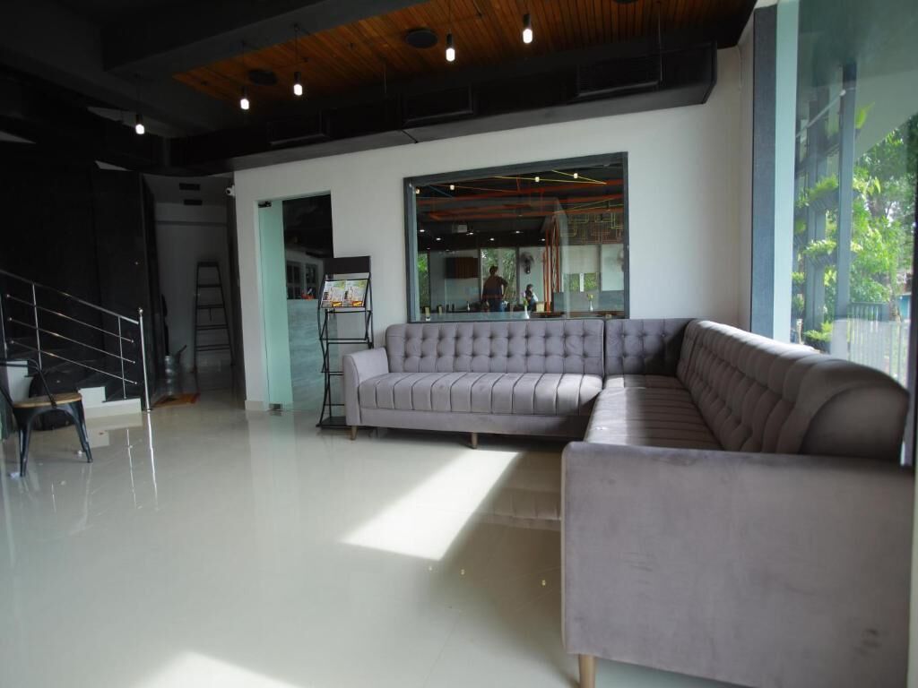 Um interior moderno com um sofá modular, uma escada e uma janela grande.