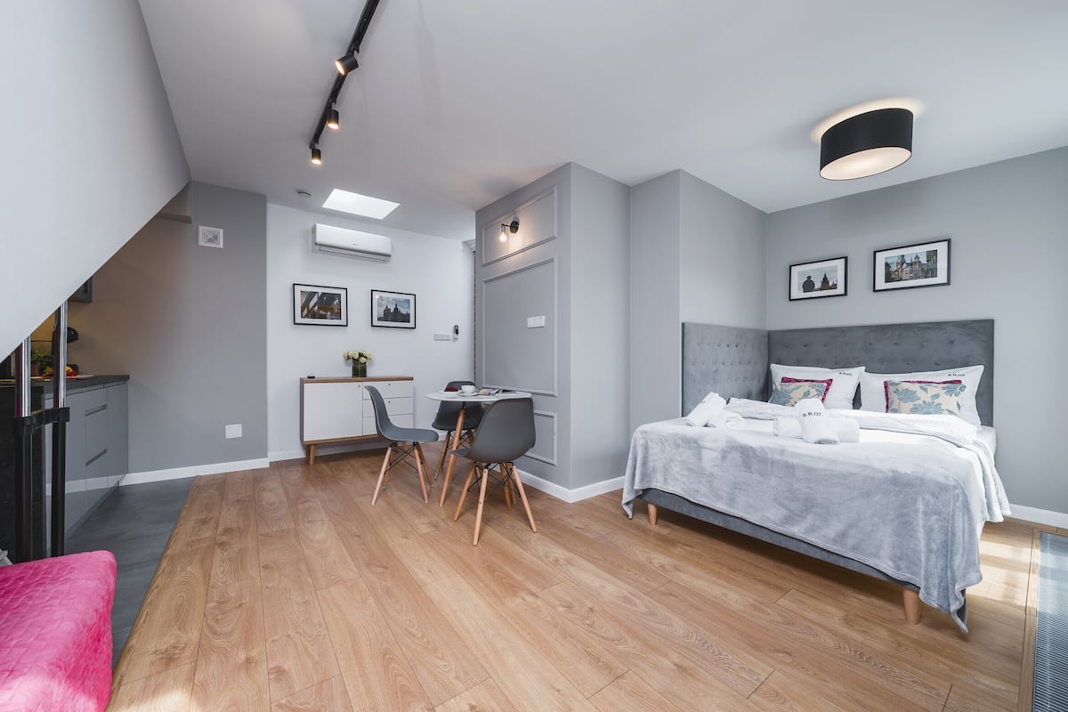 Un dormitorio moderno con cama, escritorio, sillas y comedor.