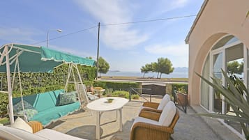 Relax on the patio with a clear view of the sea and distant mountains.