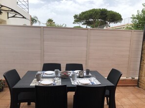 Enjoy al fresco dining with a beautifully set table for four, surrounded by a serene view.