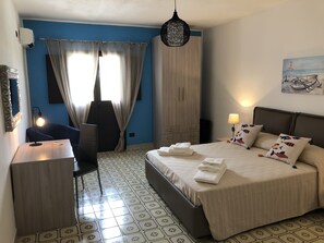 Relax in a stylish room with a large bed, desk, and comfortable chair.