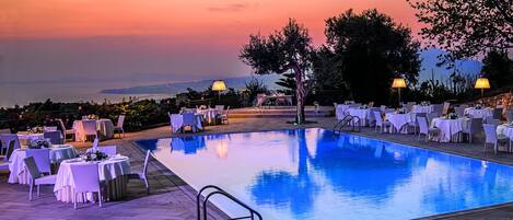 En säsongsöppen utomhuspool, parasoller och solstolar