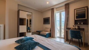 Een moderne hotelkamer met een groot bed, een bureau, een stoel en een balkon met uitzicht.