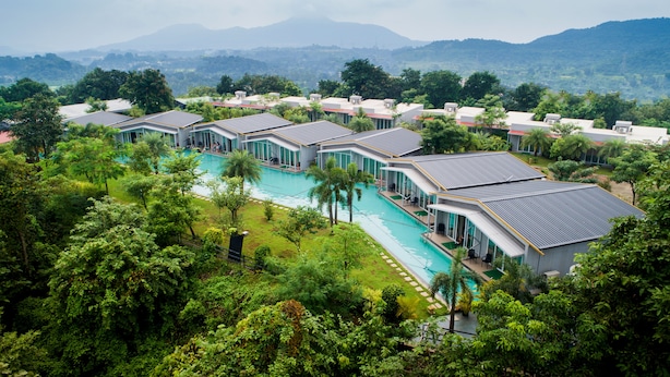 A resort with multiple buildings, a central swimming pool, and lush greenery. - The Forest Club Resort (Karjat)