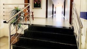 A hotel hallway with a staircase, a painting, and a door. - Hotel Skalla (Teixeira de Freitas)