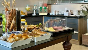 A breakfast buffet with various food items and a coffee station in a modern kitchen setting. - Hotel Skalla (Teixeira de Freitas)