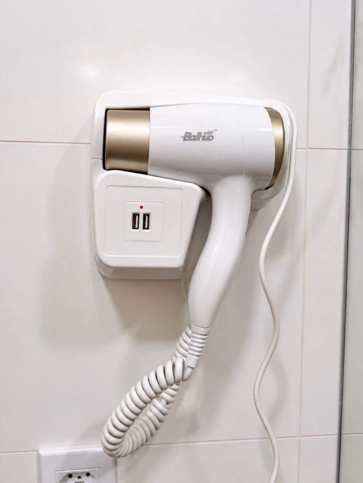 Un secador de pelo montado en la pared con un panel de control, conectado a una toma de corriente.