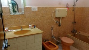 Kylpyhuone, jossa on pesuallas, wc, bidee ja kylpyamme.