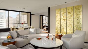 A modern living room with a sofa, armchairs, a coffee table, and a decorative wall panel.