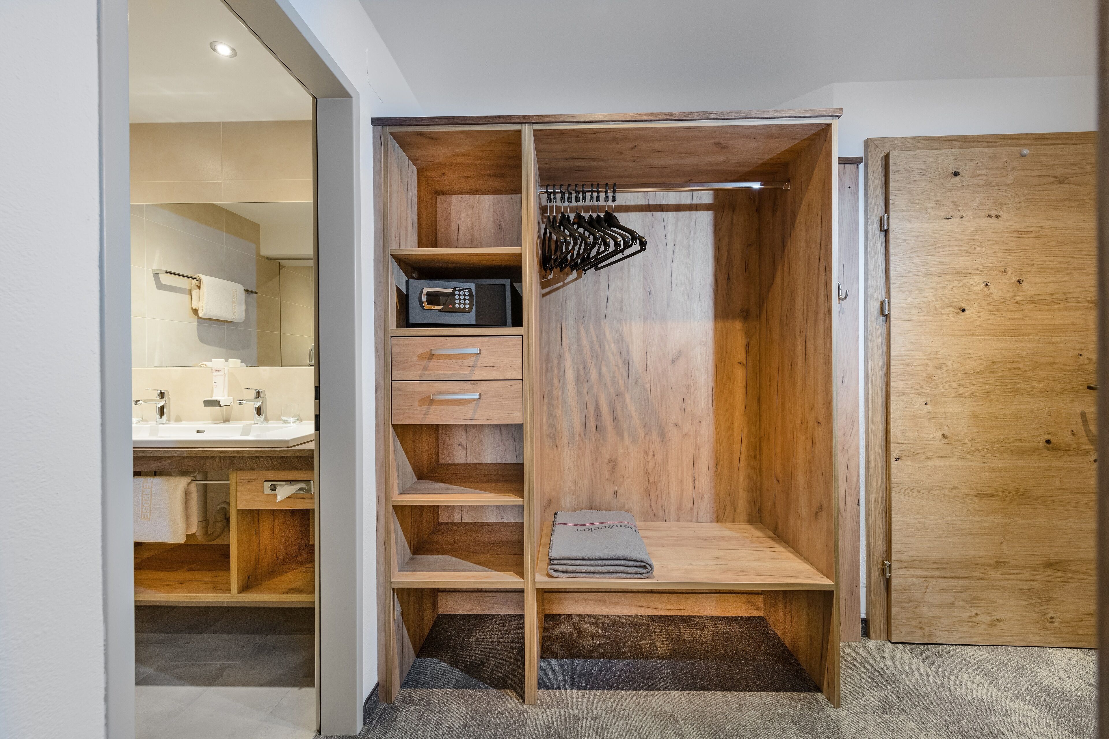 A walk-in closet with wooden shelves, a microwave, and a hanging rack.