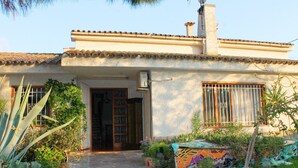 A house with a tiled roof, a chimney, and a door with decorative metalwork.